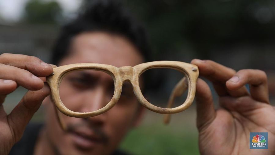Perajin menyelesaikan pembuatan kacamata yang terbuat dari limbah kayu di Workshop Urat Kayu, Kawasan Pamulang, Tangerang Selatan(24/1/2019). Berbekal pengetahuan mengenai mengolah kayu dari palet, David bersama kakanya mencoba tantangan baru untuk membuat kacamata dari limbah kayu. (CNBC Indonesia/Andrean Kristianto)