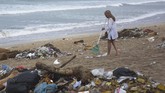 Seorang turis turut membersihkan sampah yang berserakan di kawasan Pantai Kuta, Badung, Bali, Selasa (1/1/2019). ANTARA FOTO/Nyoman Hendra Wibowo/nym.