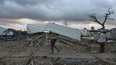 Setelah tornado mereda, para warga terlihat berjalan di sekitar perumahan yang sudah hancur, di mana mobil-mobil terbalik, dinding rumah runtuh, tiang lampu ambruk, dan pepohonan tumbang. (Reuters/Fernando Medina)