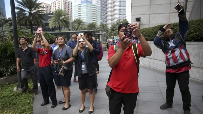 Sejumlah warga di Manila menyaksikan dan merekam aksi Alain Robert. (REUTERS/Eloisa Lopez)