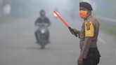 Untuk mengantisipasi kecelakaan lalu lintas karena jarak pandang terbatas membuat personel Polres Aceh Barat mengatur lalu-lintas jalan nasional Medan-Banda Aceh. (ANTARA FOTO/Syifa Yulinnas)