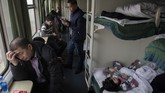 Di gerbong tidur suasana meriah terdengar sahut menyahut, keluarga mengobrol sambil menyantap makanan dan anak-anak bermain dengan seru. (Nicolas ASFOURI / AFP)