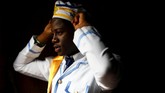 Seorang bocah lelaki yang merupakan anggota Gereja Eternal Scared Order of Cherubim & Seraphi, gereja yang berawal dari Nigeria 25 tahun lalu, membenahi topi yang dikenakannya dalam kebaktian Thanksgiving tahunan. Ia akan melayani kebaktian tersebut. (REUTERS/Simon Dawson)