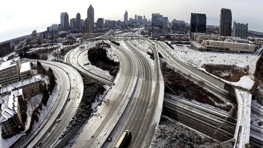 FILE - In this Jan. 29, 2014 file photo, taken with a fisheye lens looking south toward downtown Atlanta, the ice-covered interstate system shows the remnants of a winter snow storm, in Atlanta. The National Weather Service projects that up to an inch (2.5 centimeters) of snow is possible Tuesday in Atlanta, with up to 2 inches (5 centimeters) in far northern suburbs. Forecasters warn of the possibility of ice-glazed roads and highways. (AP Photo/David Tulis, File)