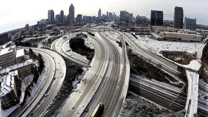 salju as, amerika serikat FILE - In this Jan. 29, 2014 file photo, taken with a fisheye lens looking south toward downtown Atlanta, the ice-covered interstate system shows the remnants of a winter snow storm, in Atlanta. The National Weather Service projects that up to an inch (2.5 centimeters) of snow is possible Tuesday in Atlanta, with up to 2 inches (5 centimeters) in far northern suburbs. Forecasters warn of the possibility of ice-glazed roads and highways. (AP Photo/David Tulis, File)