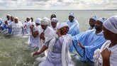 Para jemaat yang sedang melakoni pembaptisan massal yang disebut Jorodhani di tepi pantai tampak saling berinteraksi. (REUTERS/Simon Dawson)