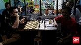 Warga menikmati waktu senggang di sore hari dengan bermain catur di depan warung kampung Ampiun. (CNNIndonesia/Andry Novelino)