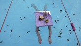 Seorang perempuan berpartisipasi di Kejuaraan Renang Air Dingin di Tooting Bec Lido di London, Inggris. (REUTERS/Hannah McKay)