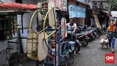 Seorang pria mengayuh 'kincir' untuk anak-anak, hiburan untuk anak-anak kecil di kawasan kampung Ampiun. (CNN Indonesia/Andry Novelino)