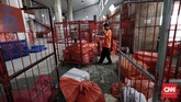 Petugas mengangkut barang paket yang akan didistribusikan ke penerima di unit paket kantor Pos Indonesia. (CNNIndonesia/Safir Makki)