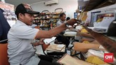 Petugas pengantar pos memyortir surat yang akan dikirimkan ke penerima di kantor Pos Indonesia. (CNNIndonesia/Safir Makki)