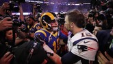 Pemain bintang New England Patriots Tom Brady coba menghibur pemain Los Angeles Rams Jared Goff usai memenangi Super Bowl 2019. (REUTERS/Mike Segar)