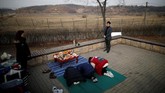 Di Korea, sebuah keluarga yang memiliki anggota keluarga Korea Utara menggelar upacara petingatan kemartian di depan pagar kawat berduri dekat zona demiliterisasi yang memisahkan kedua Korea. (REUTERS/Kim Hong-Ji)