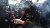 Seorang wanita membakar dupa dan berdoa untuk keberuntungan di Kuil Lama, Beijing, China pada hari pertama Tahun Baru Imlek. (AFP/Grek Baker)