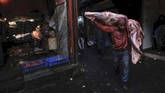 Seorang pekerja India membawa bangkai sapi di atas pundaknya di sebuah pasar daging di daerah kota tua di New Delhi. (Photo by Noemi CASSANELLI / AFP)