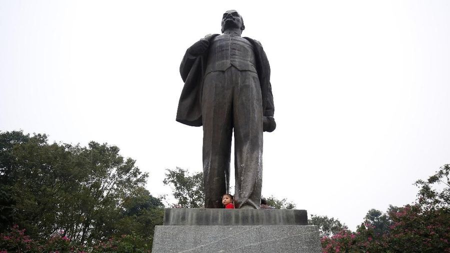 A girl plays on the statue of Russian revolutionary Vladimir Lenin in a park in Hanoi, Vietnam January 23, 2019. Picture Taken January 23, 2019.  REUTERS/Kham