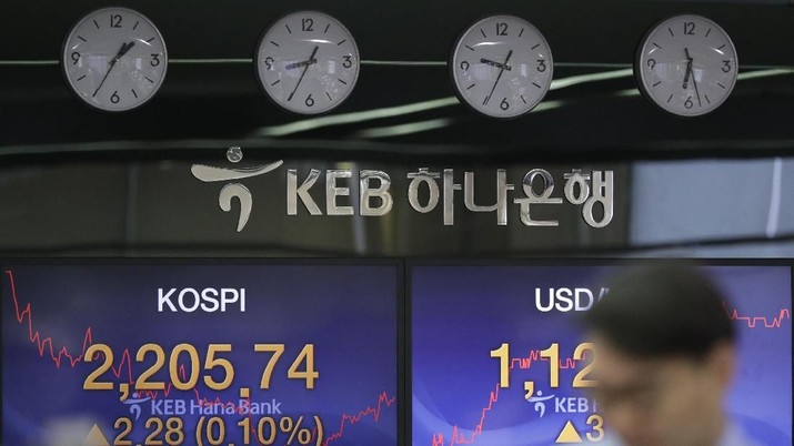 South Korea Financial Markets A currency trader walks by screens showing the Korea Composite Stock Price Index (KOSPI), left, and the foreign exchange rate between U.S. dollar and South Korean won at the foreign exchange dealing room in Seoul, South Korea, Thursday, Feb. 7, 2019. Asian shares were mostly higher Thursday on news that the Reserve Bank of Australia may cut interest rates, driving hopes that other central banks could come to the same conclusion. (AP Photo/Lee Jin-man)