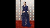 Lily Collins sukses membuat gaun biru terlihat elegan. Gaun dengan rok mini berlayer transparan dan dipadukan dengan jaket crop top. (Photo by Tolga AKMEN / AFP)