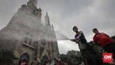 Petugas PMK menyemprotkan air di halaman Gereja Katedral dalam kegiatan Grebek Bersih yang digelar untuk menyambut HUT ke-100 Damkar. (CNN Indonesia/Adhi Wicaksono)