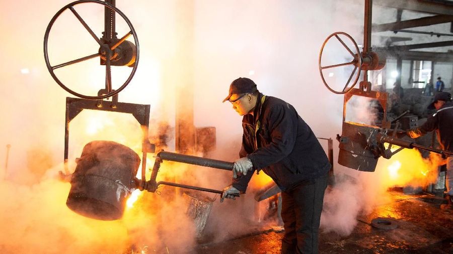 A worker pours molten iron into a mould at a mill manufacturing marine engine components in Huaian, Jiangsu province, China February 11, 2019. Picture taken February 11, 2019. REUTERS/Stringer