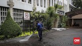 Seorang petugas menyemprot air dengan media selang untuk membersihkan halaman Katedral dalam rangka HUT ke-100 Damkar, Jakarta Pusat, Selasa (12/2). (CNN Indonesia/Adhi Wicaksono)