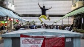 Turis asyik berfoto di balik spanduk larangan berfoto tanpa izin di suatu pemukiman padat di Hong Kong.