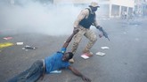 Juru bicara Kepolisian Nasional, Gary Desrosiers, mengatakan 14 personel mengalami cedera, sebagian besar karena lemparan batu demonstran. (Reuters/Jeanty Junior Augustin)