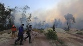 Sejumlah petugas gabungan dari BPBD, TNI, polisi berupaya memadamkan kebakaran hutan dan lahan dekat permukiman warga, di Kecamatan Dumai Barat, Kota Dumai, Dumai, Riau, 12 Februari 2019. (ANTARA FOTO/Aswaddy Hamid)