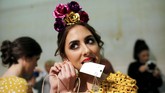 Seorang model mengenakan pakaian karya Inmaculada Martinez sedang bersolek di belakang panggung, dalam peragaan busana internasional Flamenco SIMOF di Sevila, Spanyol. (REUTERS/Marcelo del Pozo)