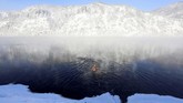 Anggota klub renang musim dingin sedang menjajal air beku di sungai Yenisei, kota Divnogorsk, Rusia, saat sesi rutin mingguan mereka. Saat itu suhu udara mencapai minus 28 derajat celcius. (REUTERS/Ilya Naymushin)
