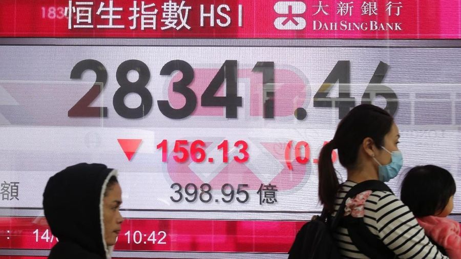 Two women stand in front of an electronic board showing Hong Kong share index outside a bank in Hong Kong, Thursday, Feb. 14, 2019. Asian stocks were mostly lower on Thursday as China and the U.S. kicked off two days of trade negotiations in Beijing. (AP Photo/Kin Cheung)