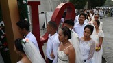 Di sudut lain Manila, sejumlah pasangan suami istri merayakan Hari Valentine dengan mengikuti agenda pernikahan masal pada Kamis (14/2). Sebanyak 200 pasangan tercatat mengambil bagian dalam gelaran tersebut. (Photo by TED ALJIBE/AFP)
