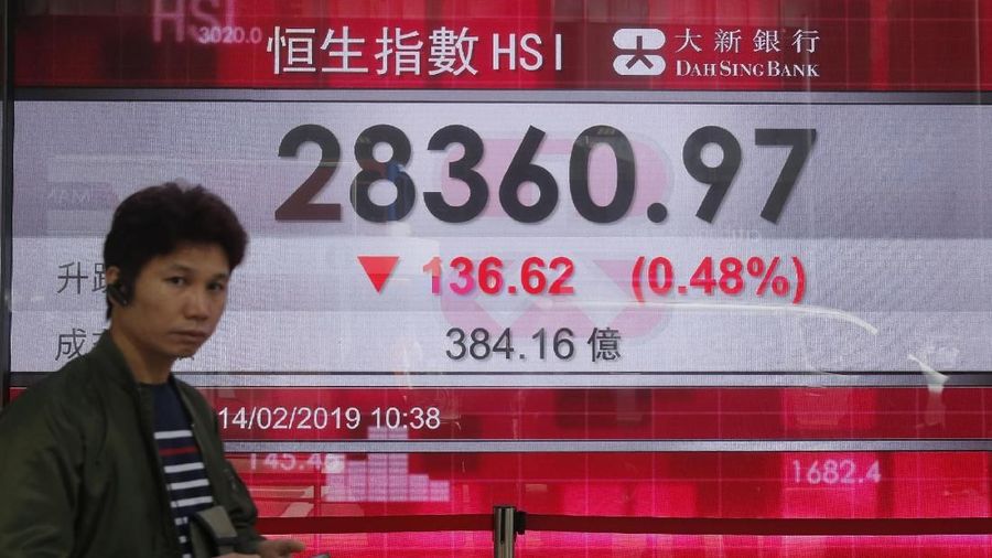 Two women stand in front of an electronic board showing Hong Kong share index outside a bank in Hong Kong, Thursday, Feb. 14, 2019. Asian stocks were mostly lower on Thursday as China and the U.S. kicked off two days of trade negotiations in Beijing. (AP Photo/Kin Cheung)