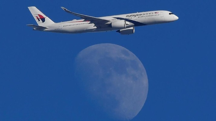 maskapai pesawat Malaysia Airlines A Malaysian Airlines passenger aircraft is seen flying in front of the moon, over London, Britain, February 15, 2019. REUTERS/Toby Melville