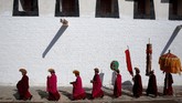 Ribuan biksu, penduduk, dan wisatawan di Tibet berkumpul kala sinar matahari pertama mengenai thangka Budha raksasa yang terbentang di lereng bukit. (REUTERS/Aly Song)