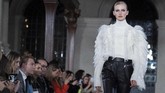 Detail feminin yang dikombinasikan dengan sentuhan maskulin serta bulu dan ruffles membuat gaya ini tampil elegan. (Photo by Niklas HALLEN / AFP)
