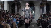 Sentuhan silver sequin dengan gaya boho juga ditampilkan oleh Koma. (Photo by Niklas HALLEN / AFP)