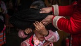 Gelungan itu terbuat dari wol, benang dan rambut leluhur mereka yang sudah meninggal. Ia kemudian dibungkus dengan kain warna putih dan tanduk binatang. (Photo by FRED DUFOUR / AFP)