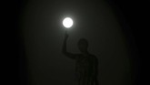 Supermoon terjadi akibat Bulan bergerak mengelilingi Bumi dalam bentuk elips bukan lingkaran. Tampak supermoon berada di atas Liberty Monument di Nicosia, Cyprus. (AP Photo/Petros Karadjias)