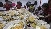 Di Kediri, Jawa Timur, warga Tionghoa berkumpul makan makanan khas Capo Go Meh, yakni lontong. Sebanyak 1.100 lontong disajikan untuk dimakan bersama saat merayakan Cap Go Meh sebagai rangkaian penutupan perayaan Tahun Baru Imlek di Kelenteng Tjoe Hwie Kiong. (ANTARA FOTO/Prasetia Fauzani)