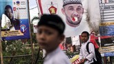 Hal yang rutin terjadi setiap lima tahun di mana alat peraga kampanye menjamur jelang Pemilu. Tampak seorang pelajar melintas di depan spanduk calon legislatif di Lhoksumawe, Aceh yang dibakar orang tak bertanggungjawab. (ANTARA FOTO/Rahmad)