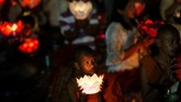 Yang menarik adalah saat malam tiba. Para biksu—masyarakat juga bisa ikut berpartisipasi—mengenakan busana kebesarannya dan membawa mangkuk berisi lilin. (REUTERS/Samrang Pring)