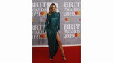 Abbey Clancy bisa jadi simbol keglamoran di karpet merah. Gaun hijau body contour dengan slit tinggi membuatnya tampil seksi. (REUTERS/Peter Nicholls)