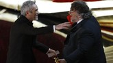Sutradara asal Meksiko, Guillermo del Toro (kanan) tak dapat menahan kegembiraan kala sahabatnya, Alfonso Cuaron membawa pulang piala Oscar untuk Best Director berkat 'Roma'. (REUTERS/Mike Blake)