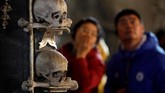 Pengunjung mengamati tengkorak kepala manusia yang terpajang di dalam gereja. (REUTERS/David W Cerny)