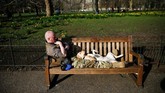 Pria duduk santai di bangku Taman St James, London, Inggris. (REUTERS/Henry Nicholls)