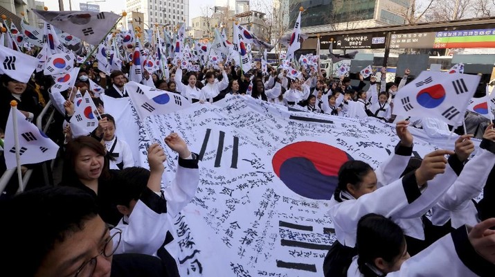 Kemeriahan Satu Abad Gerakan Samil Negara KPOP Warga Korea Selatan memberi tiga sorakan kepada negara itu saat mereka berbaris dalam rapat umum untuk memperingati seratus tahun Gerakan Kemerdekaan Pertama Maret melawan pemerintah kolonial Jepang (1910-45), di Seoul, Korea Selatan, Jumat, 1 Maret 2019. (AP / Ahn Young-joon)