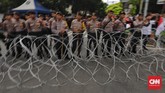 Polisi mengawal massa yang bergerak dari empat titik sebelum aksi digelar lepas salat Jumat. (CNN Indonesia/Adhi Wicaksono)