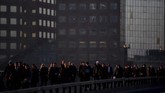 Di kota London, Inggris, para pekerja melewati Jembatan London saat jam-jam kemacetan di pagi hari. (REUTERS/Toby Melville)