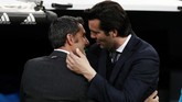 Pelatih Real Madrid Santiago Solari dan pelatih Barcelona Ernesto Valverde berpelukan sebelum laga di Santiago Bernabeu, Sabtu (2/3) malam waktu setempat. (REUTERS/Sergio Perez)